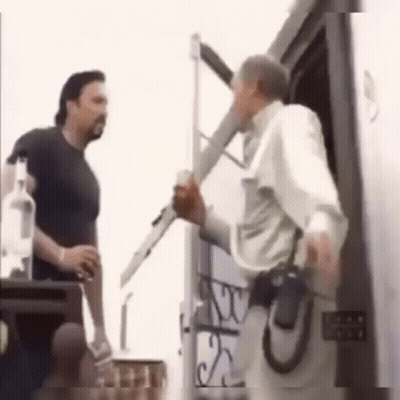 Two Men By Door, One Holding Gun GIF