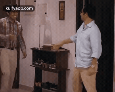 Two Men By Shoe Rack One Reaching GIF