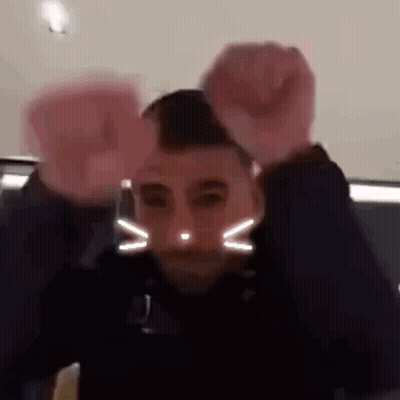 Two Men: Cat Face And Raised Fist GIF