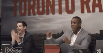Two Men Clapping In Front Of Raptors Sign GIF