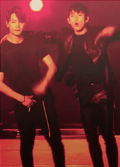 Two Men Dancing In Dark Room With Red Lights GIF