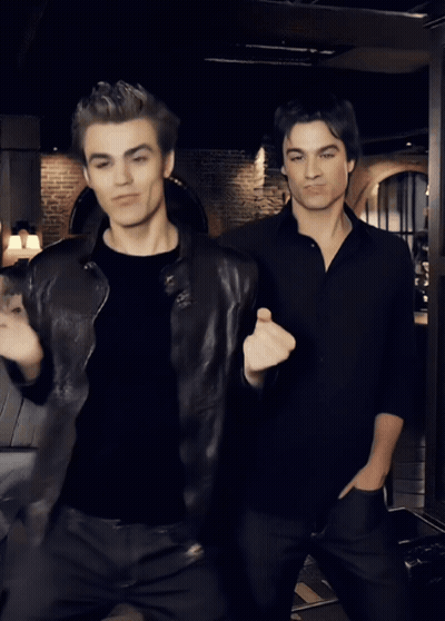 Two Men Dancing In Dark Room With Woman Sitting GIF
