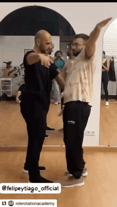 Two Men Dancing In Front Of A Mirror GIF