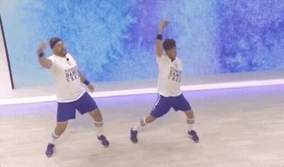 Two Men Dancing In Front Of Dance Crew Wall GIF