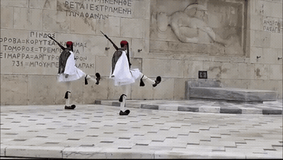 Two Men Dancing In Front Of Petraiestromenh Wall GIF