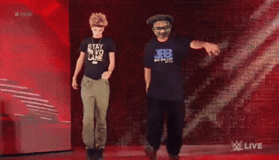 Two Men Dancing In Front Of Raw Sign GIF