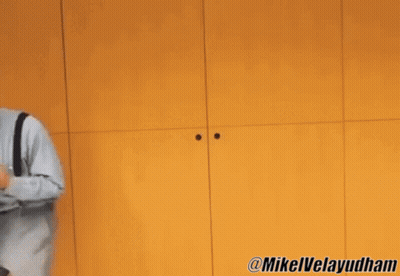 Two Men Dancing In Front Of Yellow Wall GIF