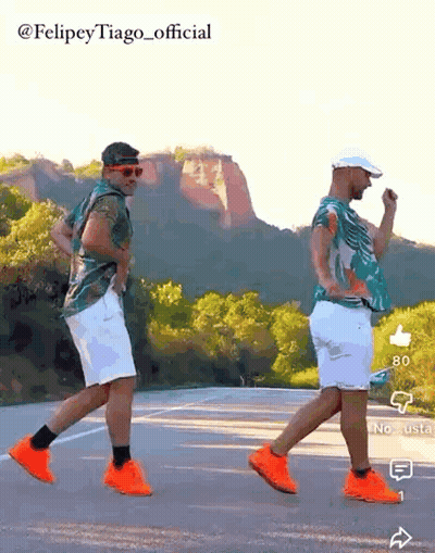 Two Men Dancing On Road In Front Of Mountain GIF