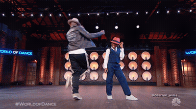 Two Men Dancing On Stage With World Of Dance Sign GIF