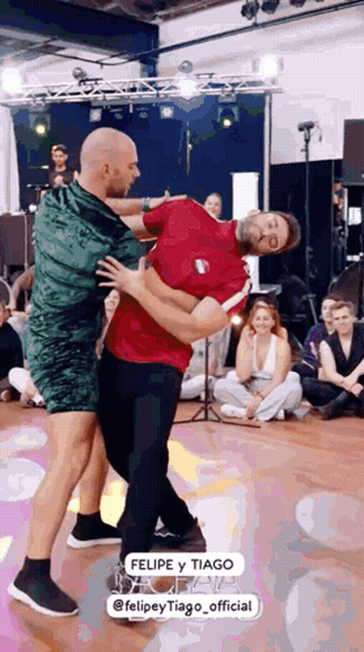 Two Men Dancing, One In Green Dress GIF