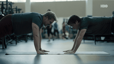 Two Men Do Push Ups On A Yoga Mat With Hbo Written On The Bottom Right GIF