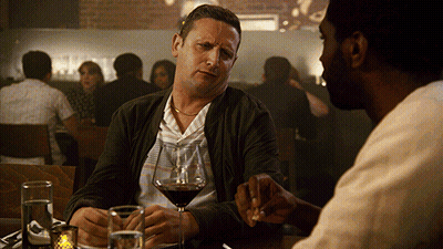 Two Men Drinking Wine And Talking At Table GIF