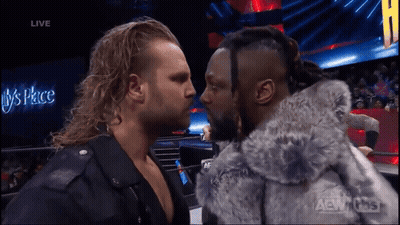 Two Men Facing Each Other In Front Of Live Sign GIF
