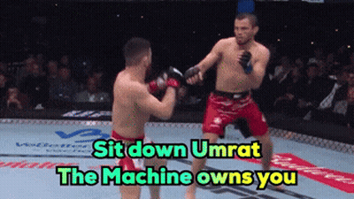 Two Men Fighting In Boxing Ring Saying Sit Down Umrat The Machine Owns You GIF