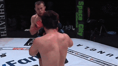 Two Men Fighting In Boxing Ring Space City Sign GIF