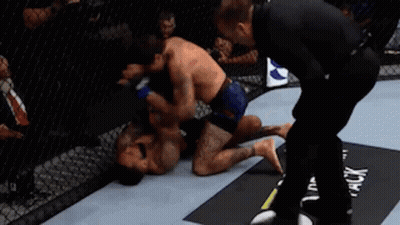 Two Men Fighting in Boxing Ring With Referee