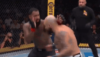 Two Men Fighting In Cage In Front Of Corona Sign GIF