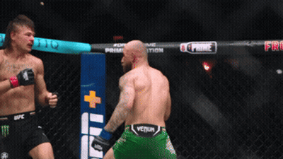 Two Men Fighting In Cage With Green Venum Shorts GIF