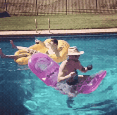 Two Men Floating On Rafts GIF