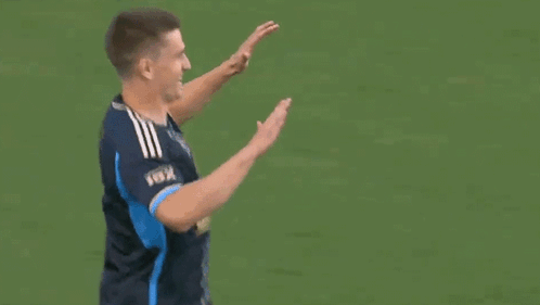 Two Men High Fiving On Field GIF