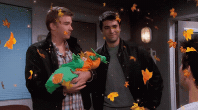 Two Men Holding Baby In Room With Falling Leaves GIF