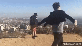 Two Men Holding Hands on Hilltop