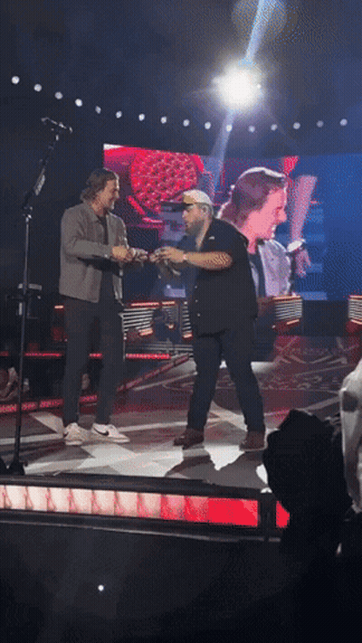 Two Men Holding Hands On Stage GIF