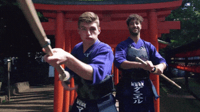 Two Men Holding Swords in Front of Red Torii Gate With Daniel on Apron
