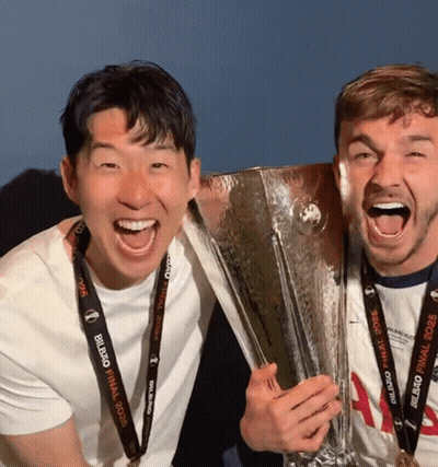 Two Men Holding Trophy One Wearing UEFA Champions League Lanyard GIF