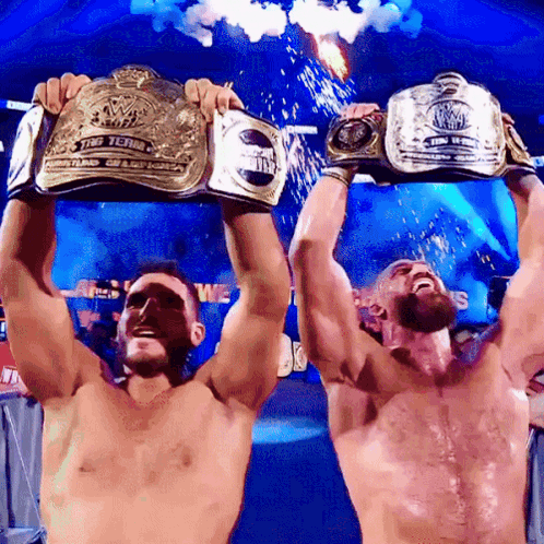 Two Men Holding Wrestling Championship Belts GIF