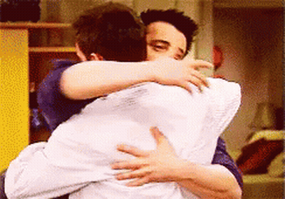 Two Men Hugging Each Other With A White Pillow GIF