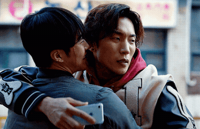Two Men Hugging Each Other With One Holding A Phone GIF