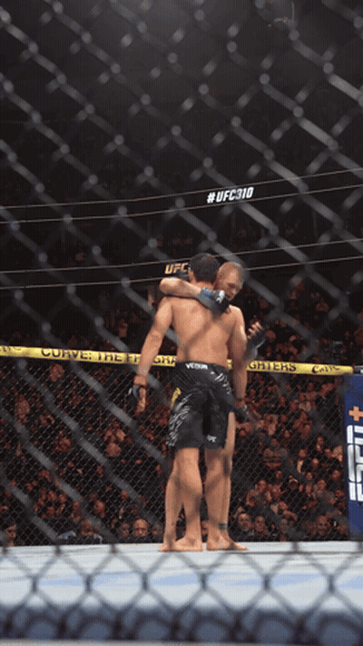 Two Men Hugging In Boxing Ring UFC310 GIF