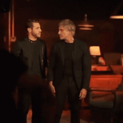 Two Men Hugging In Dark Restaurant GIF