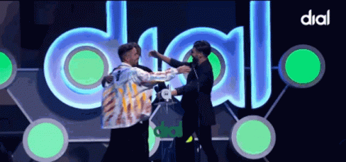 Two Men Hugging In Front Of Dial Sign GIF