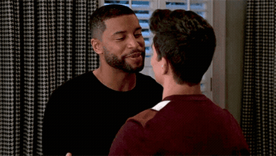 Two Men Hugging In Front Of Shuttered Window GIF