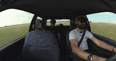 Two Men In A Car With One Wearing A Hat That Says Reebok On It GIF