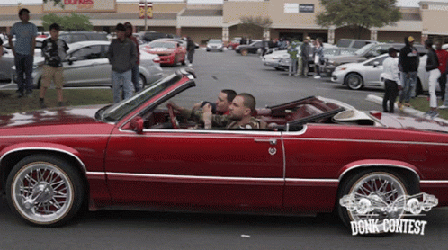 Two Men In A Red Car With The Word Donk Contest On The Bottom Right GIF