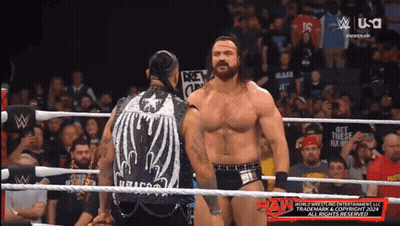 Two Men In A Wrestling Ring With A Sign That Says " Get These Hands " On It GIF