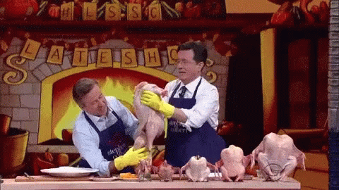 Two Men In Aprons Petting Chicken In Front Of Fireplace Saying Late Show GIF