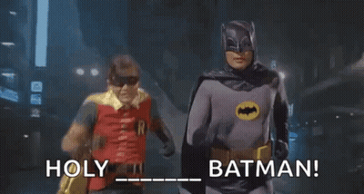 Two Men In Batman Costumes Running Down Street Holding Hands GIF