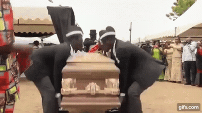 Two Men In Black Suits Dancing Around Coffin GIF