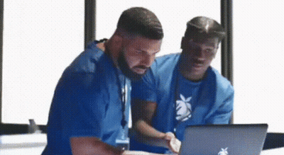 Two Men In Blue Shirts Looking At Laptop GIF
