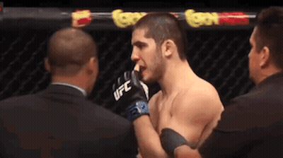 Two Men in Boxing Ring One Wearing UFC Gloves