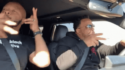 Two Men In Car One Wearing Black T-Shirt Saying Black Live GIF
