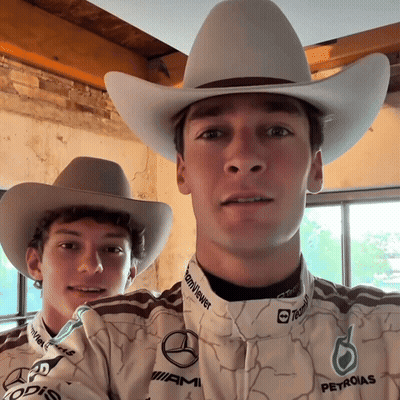 Two Men In Cowboy Hats And Petronas Shirts Posing GIF