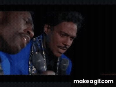 Two Men In Dark Room One Holding Microphone GIF