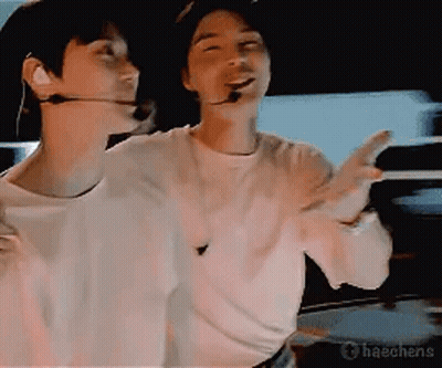 Two Men In Dark Room One With Microphone GIF
