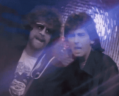 Two Men In Dark Room With Purple Light GIF