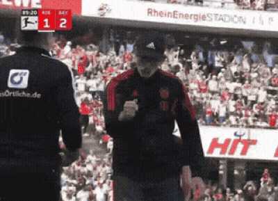 Two Men In Front Of Crowd With Sign Saying Hit GIF